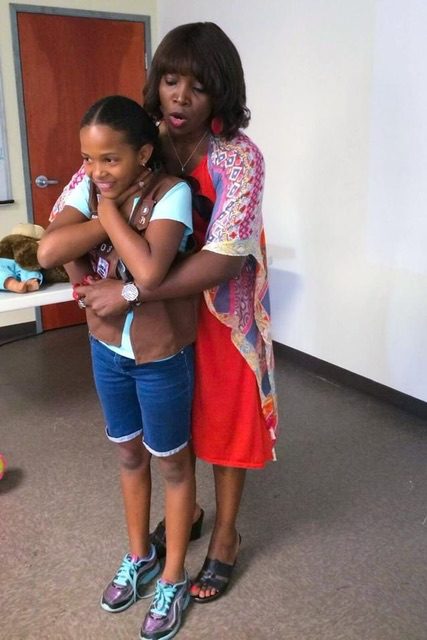 A lady along with a small girl standing in a room