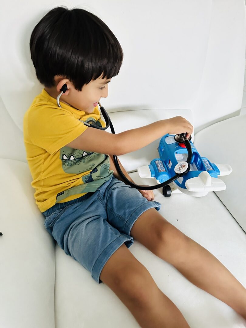 A small boy playing with an airplane