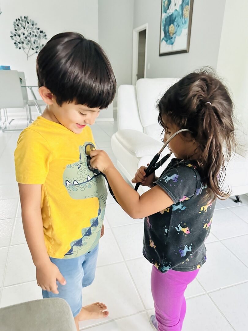 Two small children playing with stethoscope