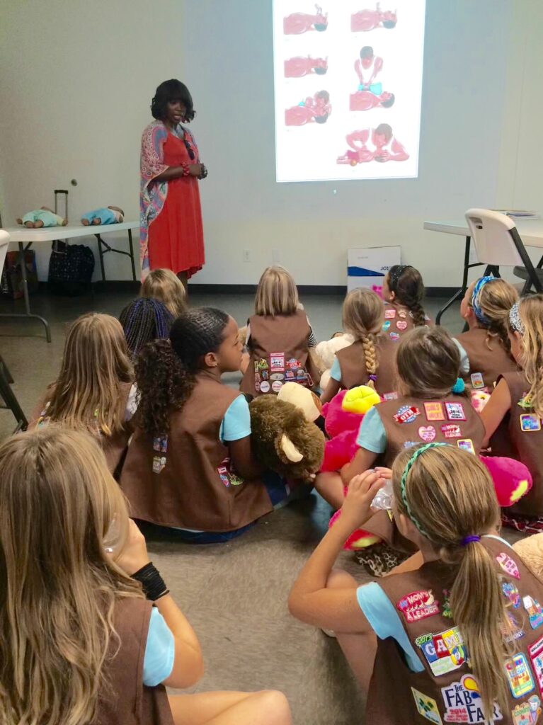 A girl teaching something to a group of peoples